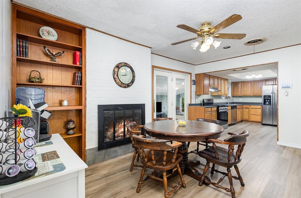 808 Ravenwood Drive Arlington, TX 76013 - Photo 9 of 27 a dining room with furniture and a fireplace