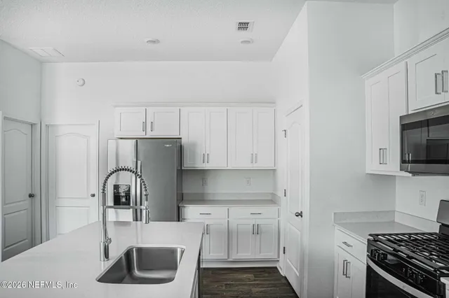 a kitchen with stainless steel appliances a refrigerator and a stove top oven