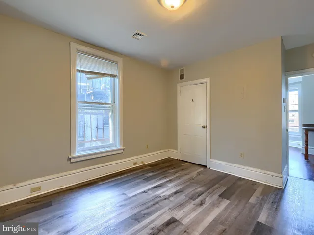 an empty room with wooden floor and a window