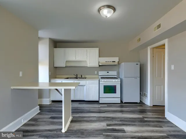 a kitchen with a stove cabinets and wooden floor