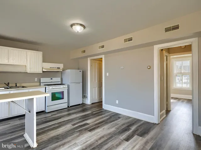 a kitchen with a refrigerator and white cabinets