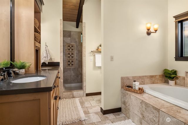 a bathroom with a granite countertop sink a toilet a mirror and shower