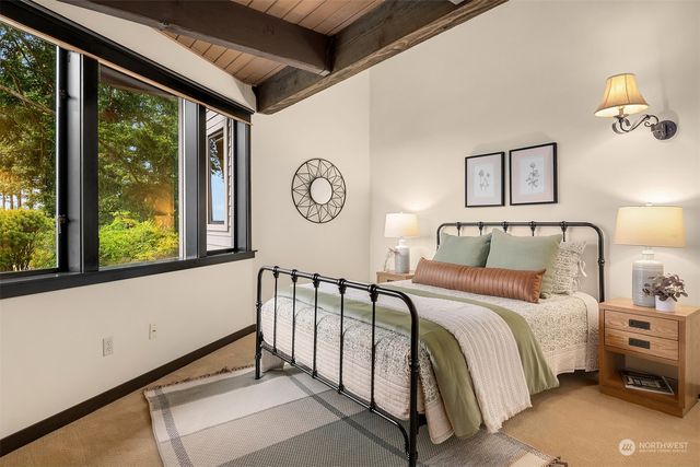 a bedroom with a bed a window and a chandelier