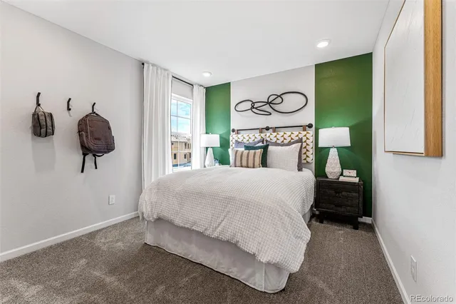 a bedroom with a bed and painting on the wall