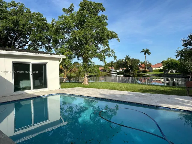 a view of a house with a big yard and potted plants