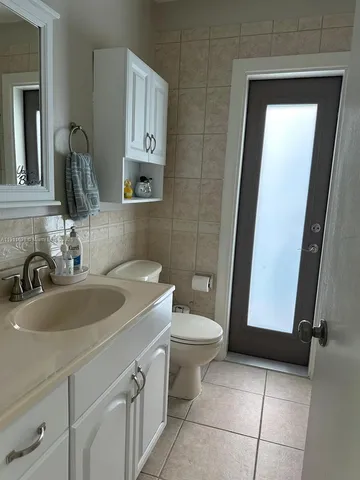 a bathroom with a sink a toilet and mirror
