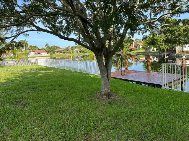 a view of backyard with tree and wooden fence