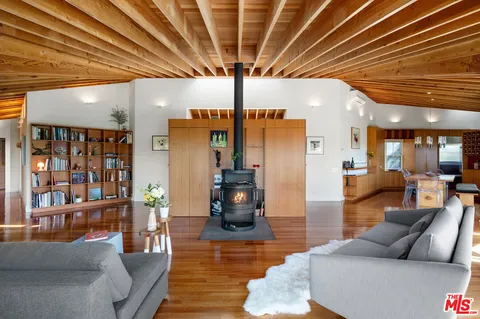 a living room with furniture floor to ceiling window and wooden floor
