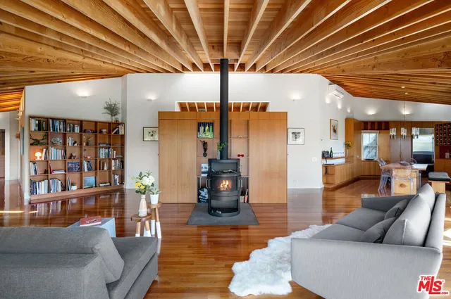 a living room with furniture floor to ceiling window and wooden floor