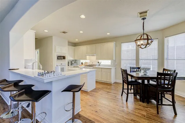 a dining room with stainless steel appliances kitchen island a table and chairs