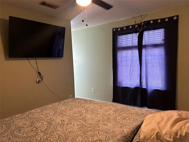 a bedroom with a bed and a flat screen tv