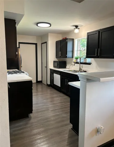a kitchen with a sink cabinets and wooden floor