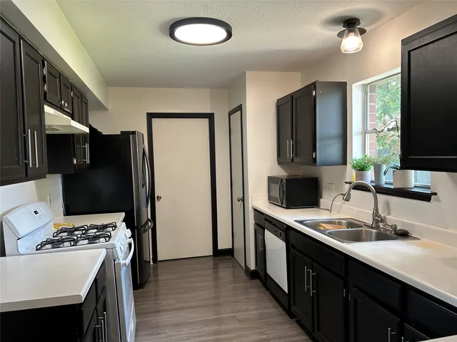 a kitchen with stainless steel appliances a sink stove and refrigerator
