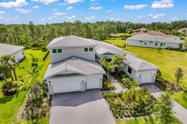 an aerial view of a house with a garden and lake view