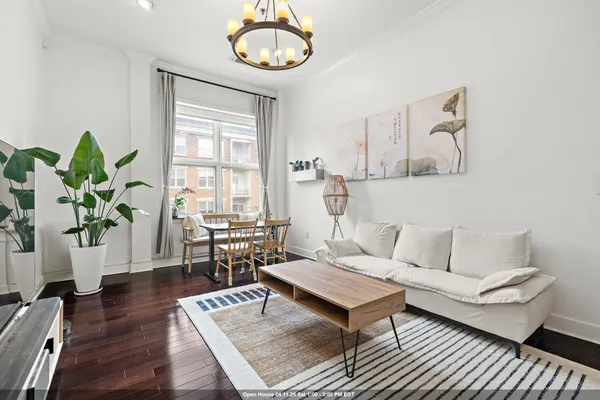 a living room with furniture a flat screen tv and a window
