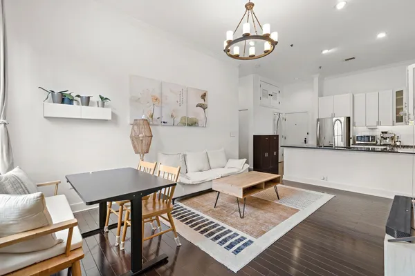 a living room with furniture a chandelier and a flat screen tv