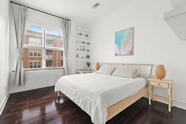 a bedroom with a bed and wooden floor