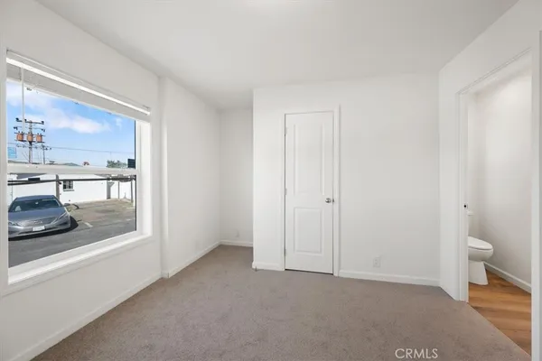 a view of a hallway with closet and wooden floor