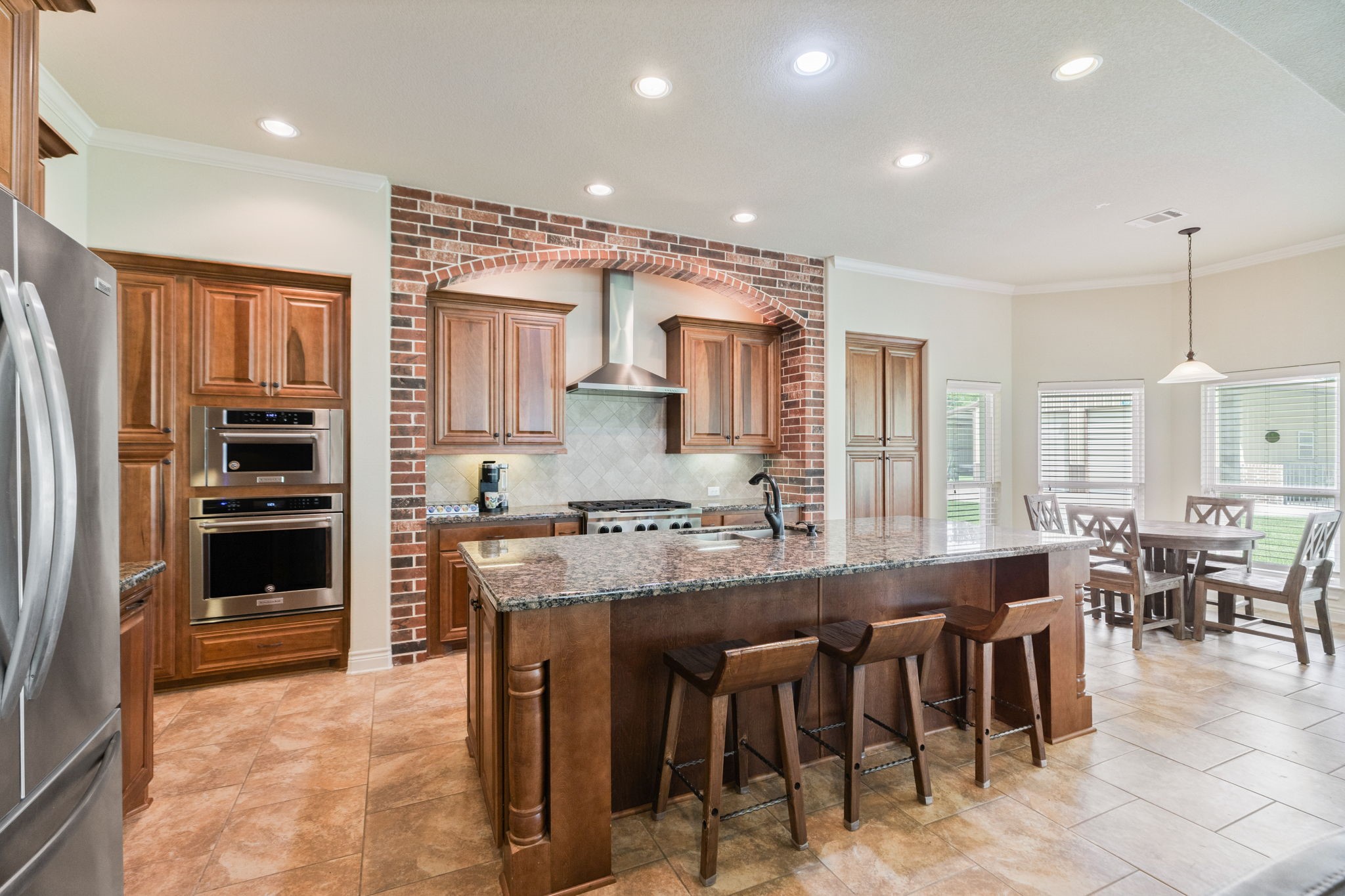 101 Pin Oak Lane Hempstead, TX 77445 - Photo 16 of 50 a kitchen with kitchen island granite countertop a stove a sink a dining table and chairs
