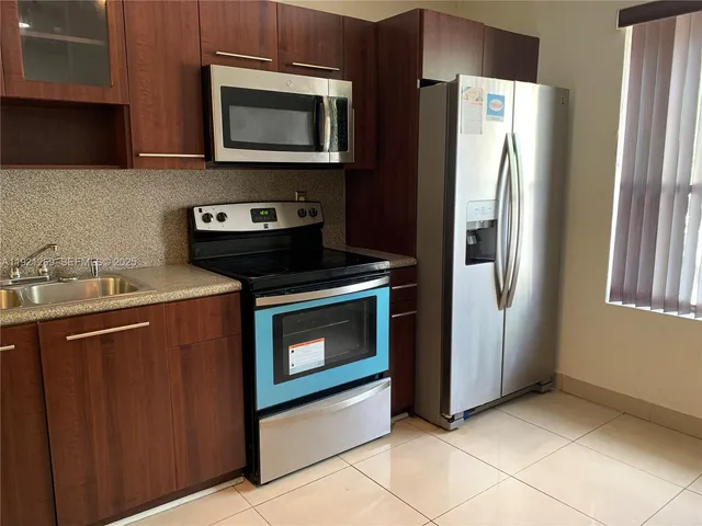 a kitchen with stainless steel appliances granite countertop a refrigerator stove and microwave