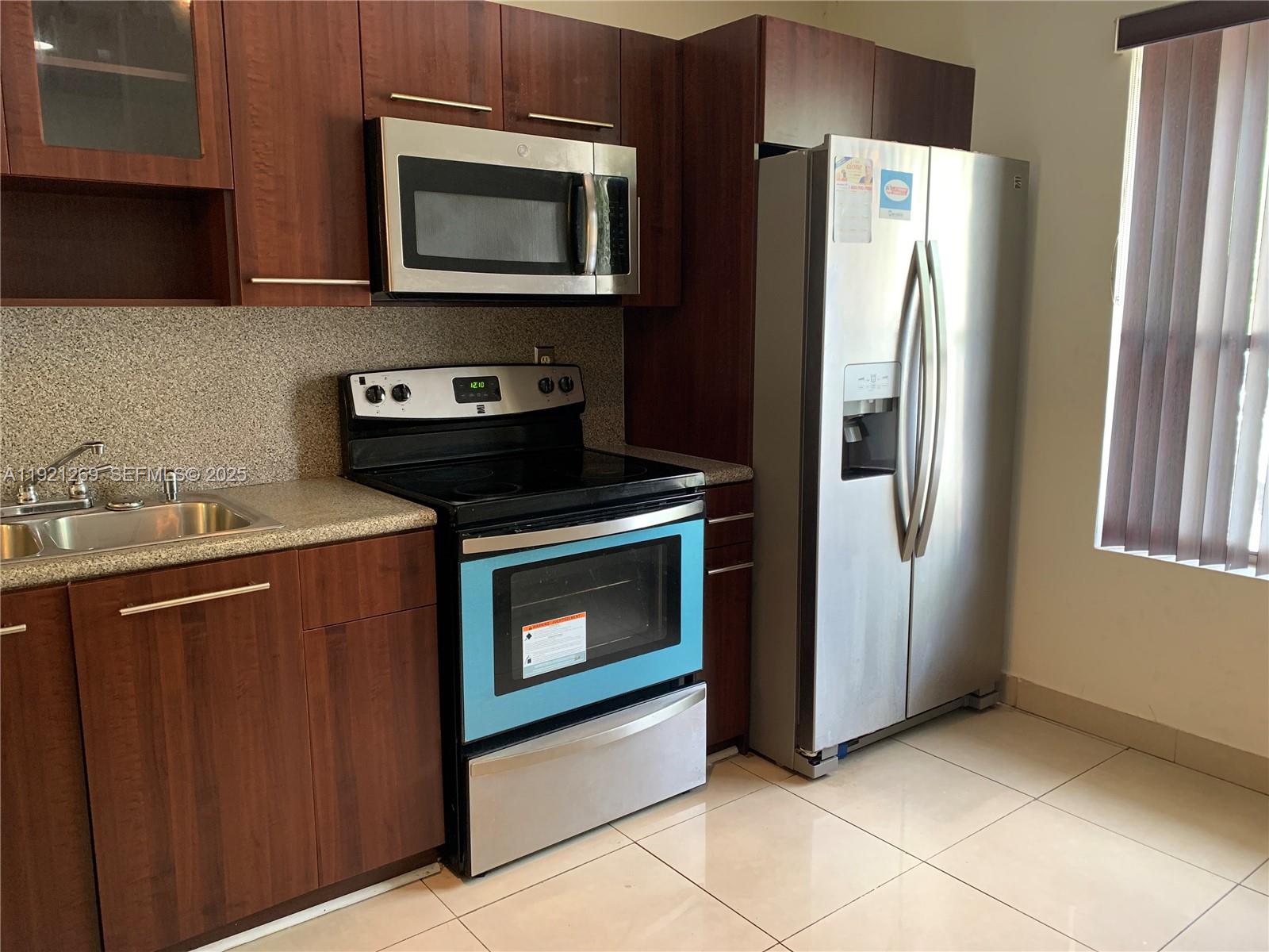 a kitchen with stainless steel appliances granite countertop a refrigerator stove and microwave
