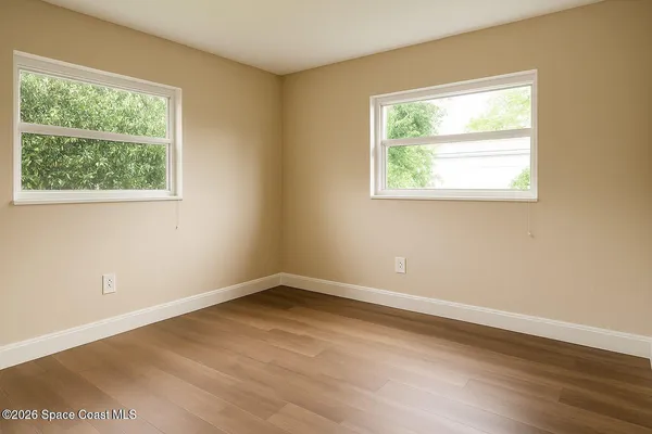 an empty room with wooden floor and a window