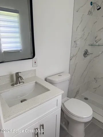 a bathroom with a sink toilet and window