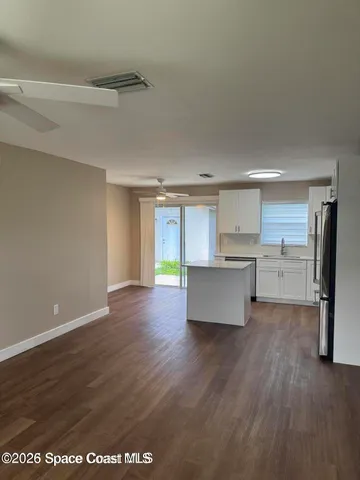 a view of kitchen with wooden floor and electronic appliances