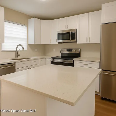 a kitchen with stainless steel appliances a refrigerator sink and white cabinets