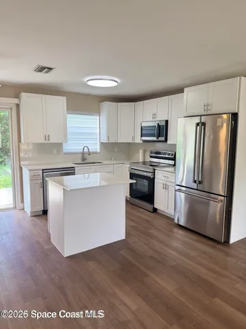 a kitchen with stainless steel appliances a refrigerator sink and microwave