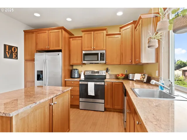a kitchen with granite countertop a stove top oven microwave and refrigerator