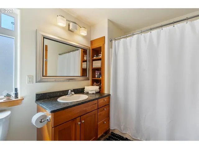 a bathroom with a granite countertop sink and a mirror