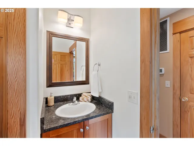 a bathroom with a granite countertop sink a mirror and a vanity