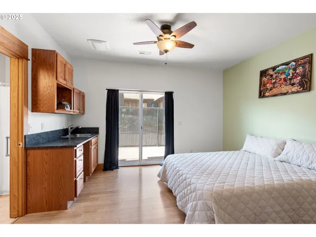 a bedroom with a bed dresser and a large window
