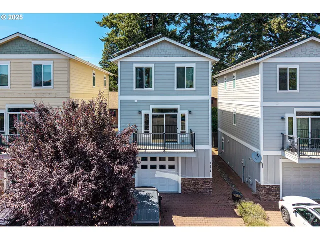 a front view of house with yard and trees in the background