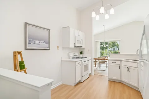 a kitchen with stainless steel appliances granite countertop a stove a sink dishwasher and a refrigerator with wooden floor