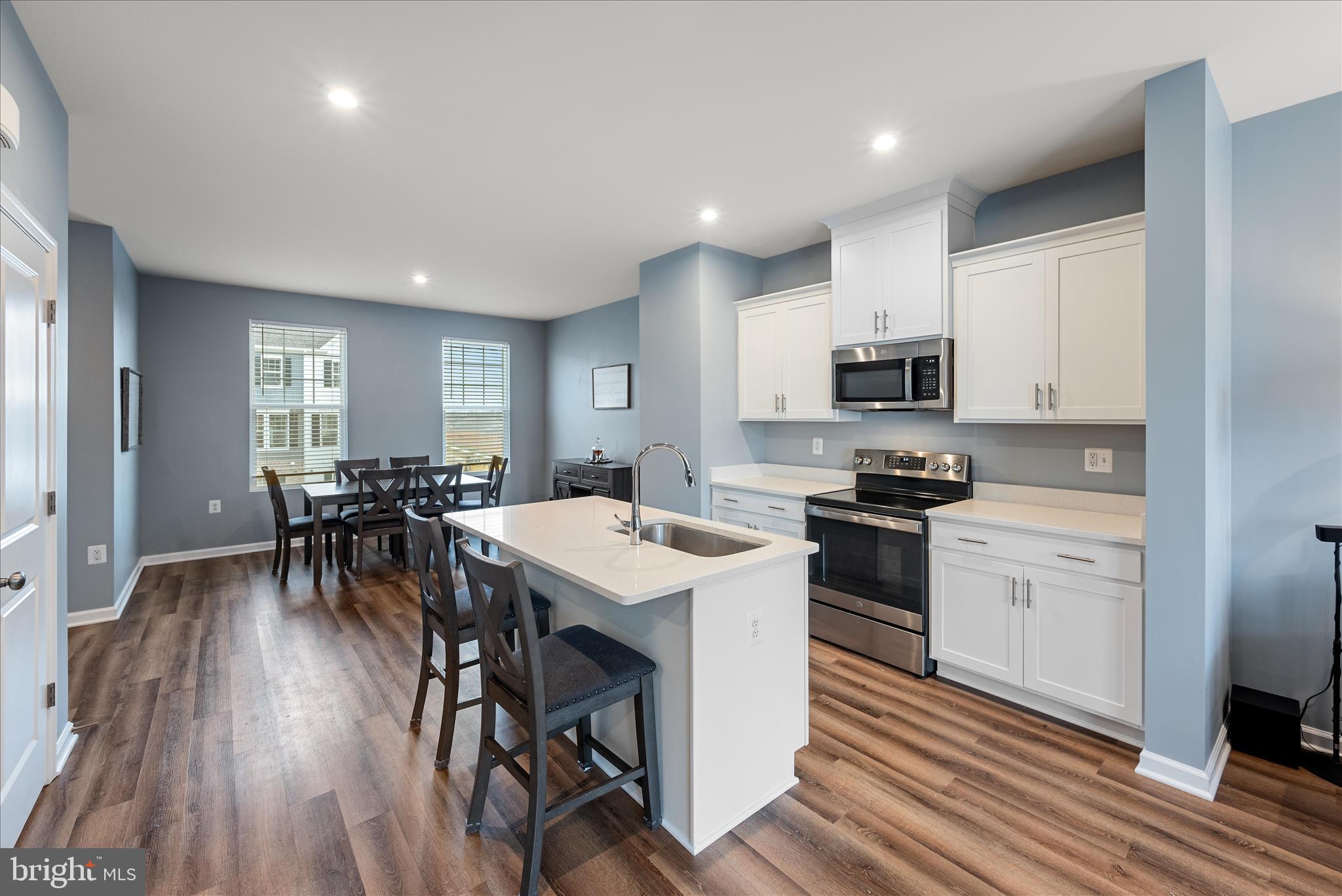 504 National Street Ranson, WV 25438 - Photo 5 of 33 a kitchen with microwave a stove a table and chairs in it