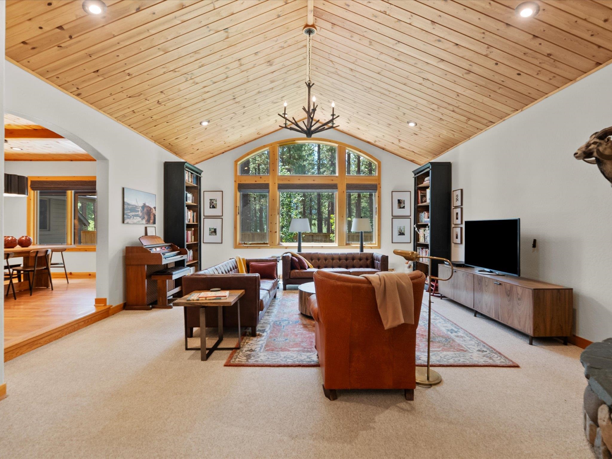 355 Quail View Circle Clio, CA 96106 - Photo 12 of 48 a living room with furniture a flat screen tv and large windows