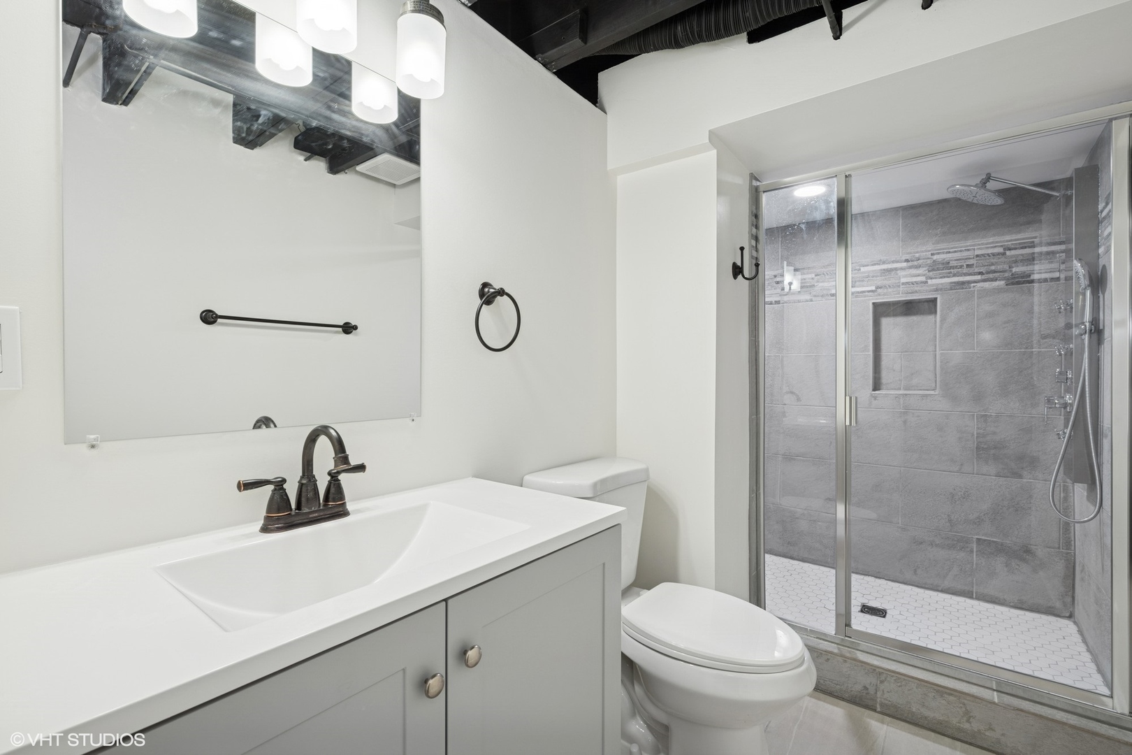 419 June Terrace Barrington, IL 60010 - Photo 12 of 18 a bathroom with a sink a toilet a mirror and shower