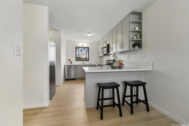 a kitchen with stainless steel appliances granite countertop a table chairs sink and cabinets