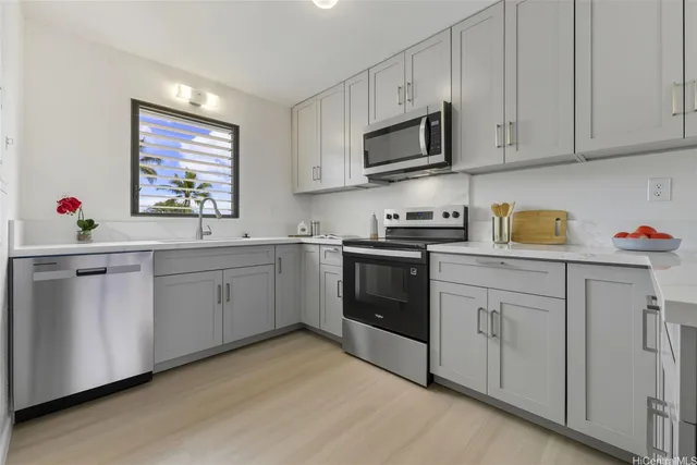 a kitchen with white cabinets sink and appliances