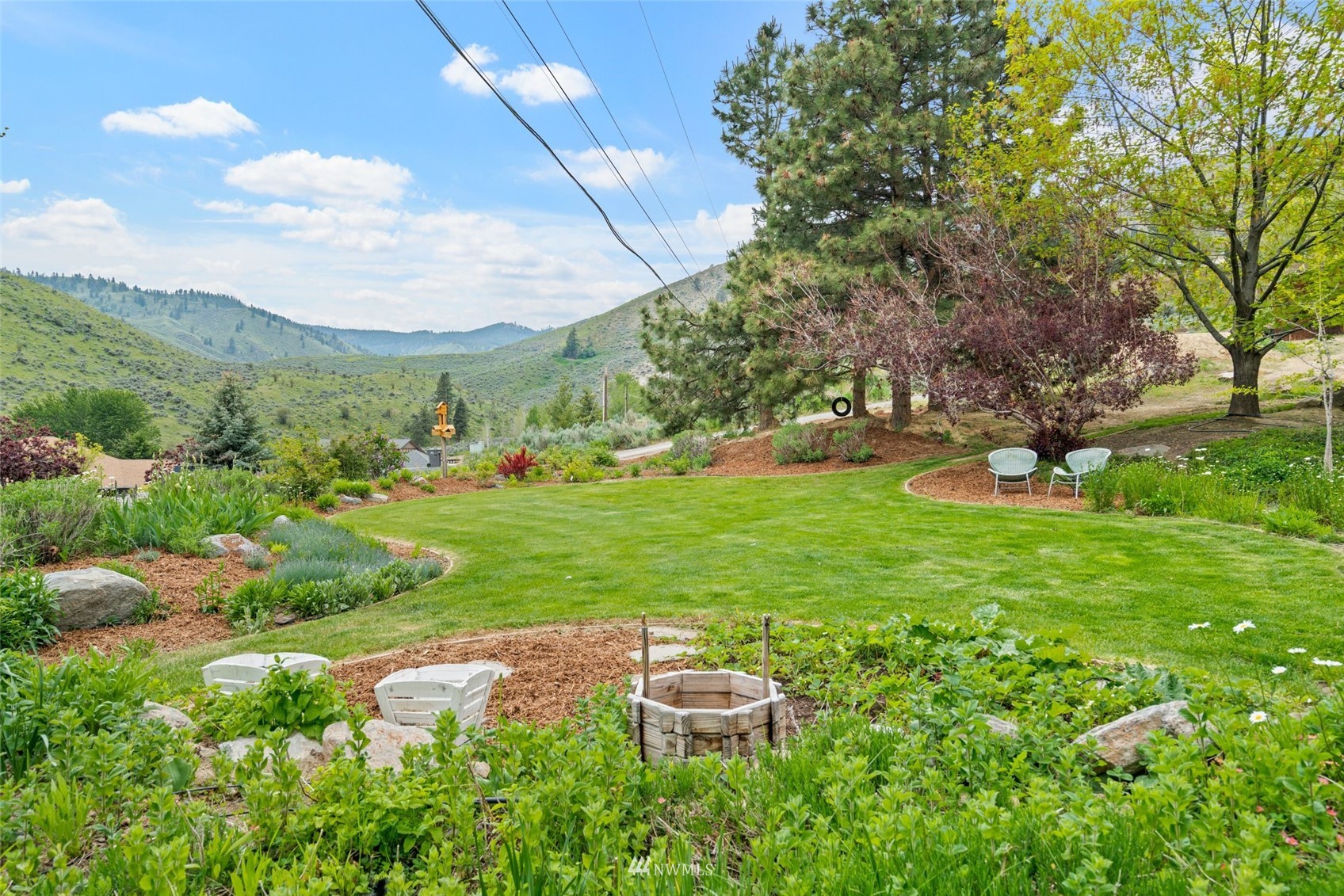 1666 Pitcher Canyon Road Wenatchee, WA 98801 - Photo 34 of 37 a backyard of a house with table and chairs plants and large trees