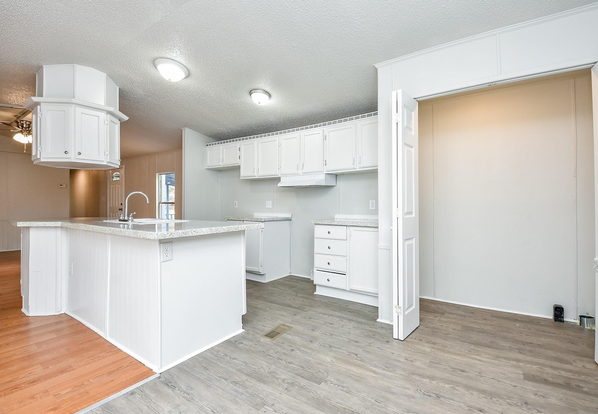12842 Roy Harris Loop Conroe, TX 77306 - Photo 22 of 36 a kitchen with white cabinets and a sink