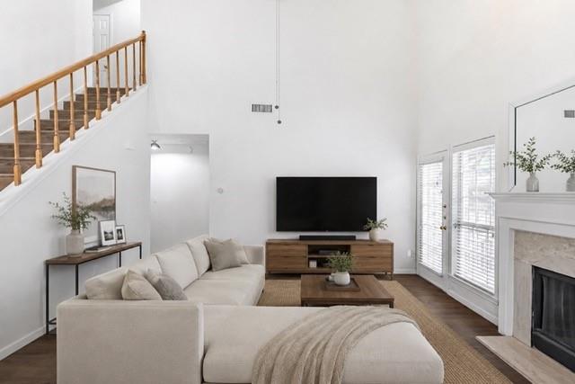 Bright living area featuring a vaulted ceiling and wood-finish flooring *Virtually Staged*