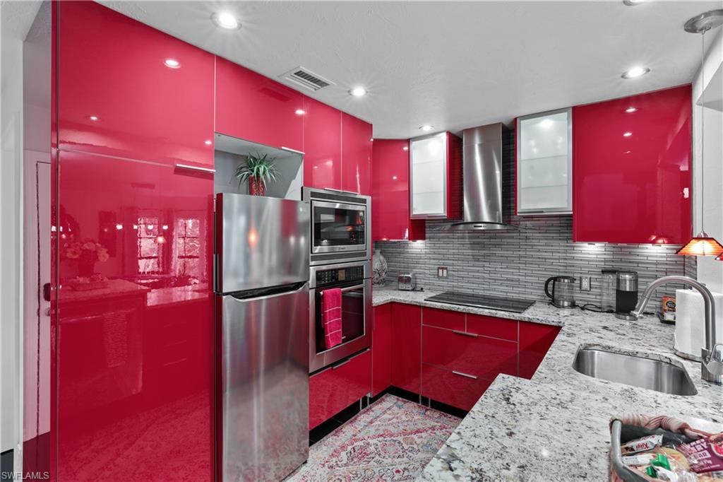 2708 Santa Cruz Boulevard Naples, FL 34112 - Photo 22 of 38 a kitchen with stainless steel appliances kitchen island granite countertop a sink stove and refrigerator