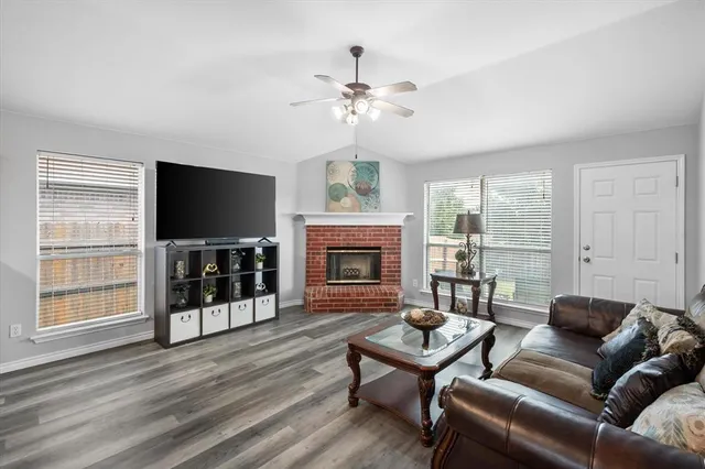 a living room with furniture a flat screen tv and a fireplace