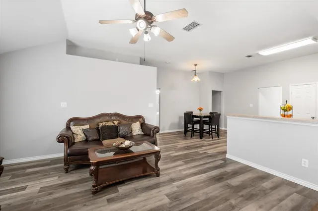 a living room with furniture and a dining table with kitchen view