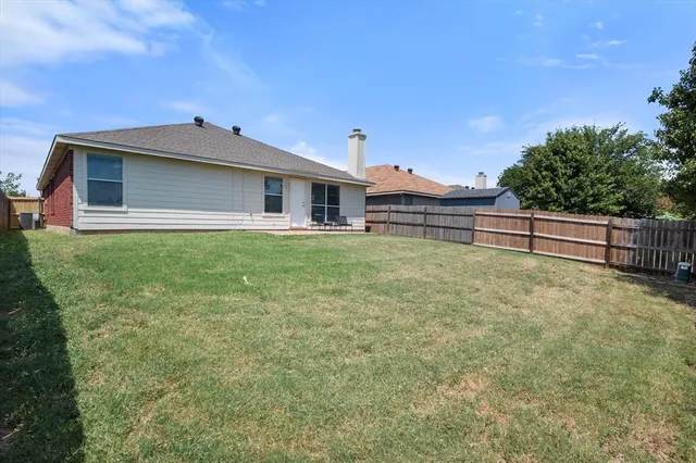 a backyard of a house with table and chairs