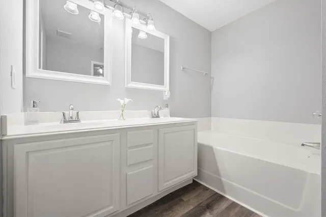 a bathroom with a tub sink and mirror
