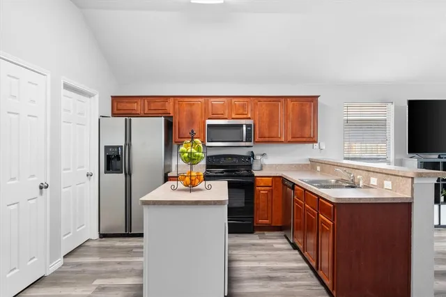 a kitchen with stainless steel appliances granite countertop a refrigerator stove and oven
